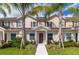 Tan three-story townhome with brown door, walkway, and landscaping at 3227 Cupid Pl, Kissimmee, FL 34747