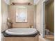 Bathroom with a large soaking tub and a window offering natural light at 7459 Gathering Dr, Reunion, FL 34747