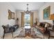 Bright sitting room with a leather sofa, coffee table, and large window with window treatments at 7459 Gathering Dr, Reunion, FL 34747