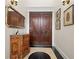 Elegant entryway with double doors, ornate console table, and large mirror at 7459 Gathering Dr, Reunion, FL 34747