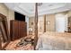 Main bedroom with a large four-poster bed, dresser, and ensuite bathroom access at 7459 Gathering Dr, Reunion, FL 34747