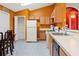 Kitchen with wood cabinets, white appliances, and a dining area at 2419 Willow Tree Ln, Kissimmee, FL 34758