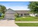 Single-story home with two-car garage and landscaped lawn at 2419 Willow Tree Ln, Kissimmee, FL 34758