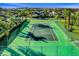 Green tennis court with surrounding fence at 730 Brunello Dr, Davenport, FL 33897