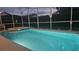 Night view of a relaxing screened-in pool and spa at 730 Brunello Dr, Davenport, FL 33897