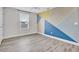 Charming bedroom with geometric accent wall and wood-look flooring at 3920 Saltmarsh Loop, Sanford, FL 32773