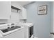 Laundry room with white washer and dryer, cabinets, and wood-paneled walls at 3920 Saltmarsh Loop, Sanford, FL 32773
