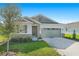 One-story home with stone and siding exterior, two-car garage, and landscaped lawn at 4252 Sawtooth Ct, Tavares, FL 32778