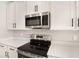 Stainless steel appliances and white cabinetry in a modern kitchen at 4252 Sawtooth Ct, Tavares, FL 32778