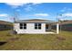 Rear view of house showing covered patio and yard at 4256 Sawtooth Ct, Tavares, FL 32778