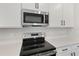 Stainless steel gas cooktop and microwave in a white kitchen at 4256 Sawtooth Ct, Tavares, FL 32778