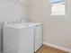 Bright laundry room features washer, dryer, and shelving at 4256 Sawtooth Ct, Tavares, FL 32778