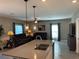 Modern kitchen island with double sink and quartz countertop at 5519 Braken Fern Way, Leesburg, FL 34748