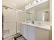 Dual vanity bathroom with white cabinets and glass shower at 2894 Mosshire Cir, Saint Cloud, FL 34772