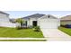 Front exterior view of a single-story home with a two-car garage and a landscaped lawn at 2894 Mosshire Cir, Saint Cloud, FL 34772