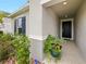 Inviting front entry with a covered porch, black front door, and potted plants at 2894 Mosshire Cir, Saint Cloud, FL 34772