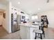 Kitchen island with bar seating, stainless steel appliances, and white cabinetry at 2894 Mosshire Cir, Saint Cloud, FL 34772