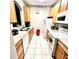 Galley kitchen with wood cabinets and white appliances at 6335 Contessa Dr # 205, Orlando, FL 32829