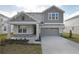 Two-story house with gray siding, stone accents, and a two-car garage at 4236 Sawtooth Ct, Tavares, FL 32778