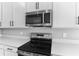 Stainless steel appliances and white cabinetry in a modern kitchen at 4236 Sawtooth Ct, Tavares, FL 32778
