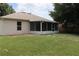 Back of house with screened porch and grassy backyard at 624 Gull Dr, Poinciana, FL 34759