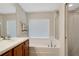Bathroom with a double vanity, tub, and window at 500 Playa Dr, Davenport, FL 33837
