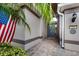 Inviting home exterior entrance with a gray door, brick walkway, and American flag at 500 Playa Dr, Davenport, FL 33837