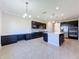 Spacious kitchen boasts dark cabinetry, stainless steel appliances, and an island at 3510 Mediterra Dr, Clermont, FL 34711