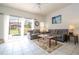 Living room with gray couch, pool view, and tiled floors at 8545 Bay Lilly Loop, Kissimmee, FL 34747