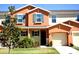 Two-story townhome with orange exterior and teal accents at 5144 Adelaide Dr, Kissimmee, FL 34746
