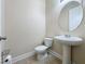 Powder room features pedestal sink and toilet at 3510 Mediterra Dr, Clermont, FL 34711