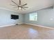 Living room with tile floors, large TV and window at 3510 Mediterra Dr, Clermont, FL 34711