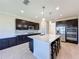 Modern kitchen with island, stainless steel appliances, and dark cabinetry at 3510 Mediterra Dr, Clermont, FL 34711