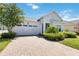 Front view of a one-story house with a white garage door and landscaped yard at 5006 Sunfalls Ave, Saint Cloud, FL 34772