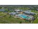 Aerial view of community with pool, clubhouse, tennis courts, and lake at 5006 Sunfalls Ave, Saint Cloud, FL 34772
