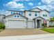 Two-story house with gray siding, three-car garage, and landscaped yard at 2867 Matera Dr, St Cloud, FL 34771