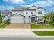 Two-story house with a three-car garage, landscaping and solar panels at 2867 Matera Dr, Saint Cloud, FL 34771