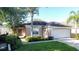 One-story house with a beige exterior, a two-car garage and manicured lawn at 3075 Barbados Ln, Haines City, FL 33844
