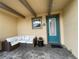 Cozy patio area with seating and a teal front door at 8079 Nemours Pkwy, Orlando, FL 32827