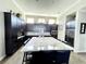 Gourmet kitchen boasts granite countertops and dark cabinetry at 8079 Nemours Pkwy, Orlando, FL 32827