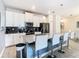 Modern kitchen with white cabinets, stainless steel appliances, and breakfast bar at 8971 Stinger Dr, Davenport, FL 33896