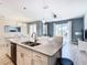 Open kitchen with island, stainless steel appliances, and white cabinets at 8971 Stinger Dr, Davenport, FL 33896