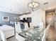 Open concept dining area with glass table and white chairs, adjacent to kitchen at 8971 Stinger Dr, Davenport, FL 33896