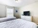 Bright bedroom with two beds, dresser, and TV at 8971 Stinger Dr, Davenport, FL 33896