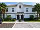 Two-story townhouse with Spanish tile roof and landscaping at 8971 Stinger Dr, Davenport, FL 33896
