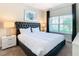Bedroom with a queen-size bed, nightstands, and large window at 8971 Stinger Dr, Davenport, FL 33896