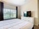Bedroom with a queen-size bed, dresser, TV, and window at 8971 Stinger Dr, Davenport, FL 33896
