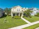Two-story house with light beige siding, landscaping, and a walkway at 2662 Trafalgar Blvd, Kissimmee, FL 34758