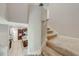 Well-lit staircase with carpet runner and kitchen view at 2662 Trafalgar Blvd, Kissimmee, FL 34758