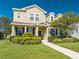 Two-story house with light beige siding, landscaping, and a walkway at 2662 Trafalgar Blvd, Kissimmee, FL 34758